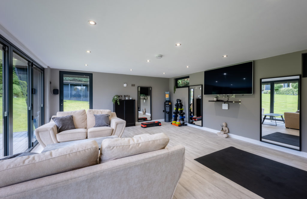Bespoke garden room, multipurpose interior with sofas and gym equipment